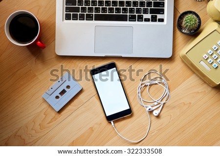 Office table with smart phone, notebook and, Cassette tape, cup of coffee. View from above with copy space