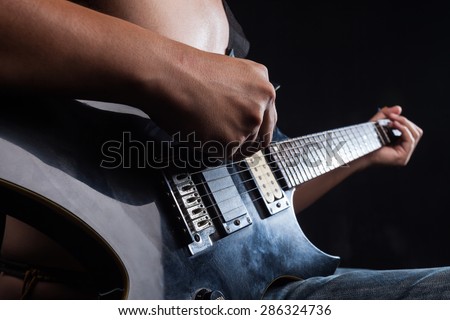 Rockman Playing Electric Guitar Close Up Photography. Hands on Guitar. Elegant Brown Color Grading.