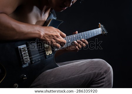 Rockman Playing Electric Guitar Close Up Photography. Hands on Guitar. Elegant Brown Color Grading.