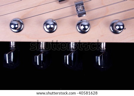 Guitar headstock, strings and tuners against a black background