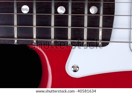 Close-up of red and white guitar neck, strings and body