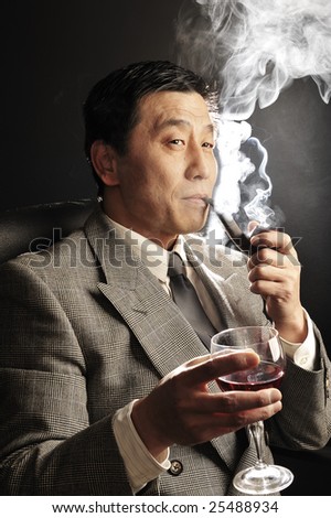 Asia businessman Drinking red wine and smoking