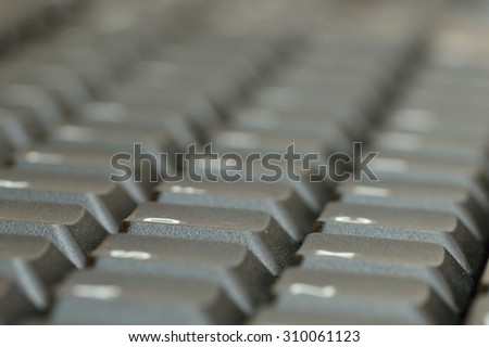 Computer keyboard. Close up of mostly blurred bands of keys on an acute angle.