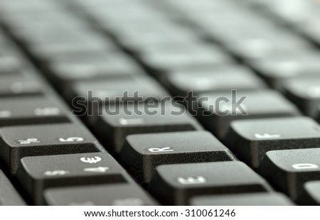 Computer keyboard.  Close up of mostly blurred, light, bands of keys on an angle.