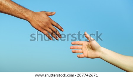 Black hand man helping white person - Different skin color hands united against racism and racial problem - Concept of humane aid between different cultures and religion - friendship between peoples