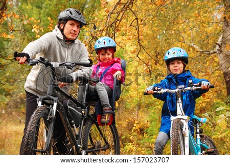 Happy family on bikes in autumn park, having fun, sport and cycling with kids
