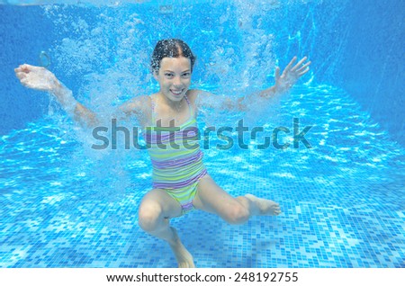 Kid swims in pool underwater, girl swimming, playing and having fun, children water sport