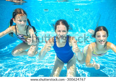 Family swim in pool underwater, happy active mother and children have fun in water, kids sport on family vacation