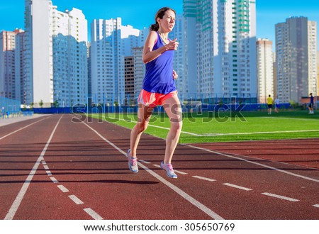 Happy active woman jogging on track, running and working out on stadium, sport and fitness in modern city
