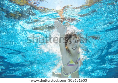 Child swims in pool underwater, happy active girl has fun in water, kid sport on family vacation