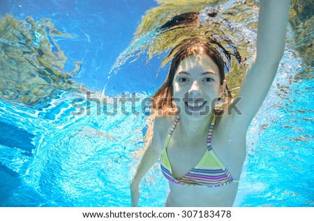 Child swims in pool underwater, happy active girl has fun in water, kid sport on family vacation
