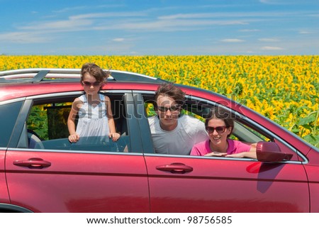 Family summer vacation, travel by car. Happy active parents with child having fun in car trip, looking at beautiful nature