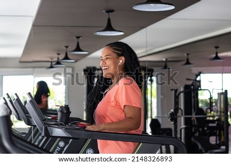 
Smiling young brazilian woman with braided hair orange t-shirt and headphones on gym mat Imagine de stoc © 