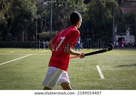 Brazilian grass hockey player with stick in hands watching the game from afar Imagine de stoc © 