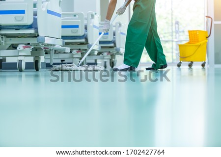 Cleaner using mops, cleaner with mop and uniform cleaning hall floor, hospital cleaning floor with mop in patient room the hospital epoxy floor.