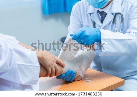 Close-up hand wear medical gloves  Of Doctor Hand Tying Bandage On The Leg Of Patient In Clinic, osteophytes and heel, fascia Foto d'archivio © 