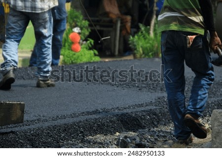 Similar – Foto Bild Arbeiter mit Asphaltfertigerwerkzeug beim Straßenbau.