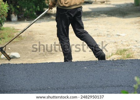 Similar – Foto Bild Arbeiter mit Asphaltfertigerwerkzeug beim Straßenbau.