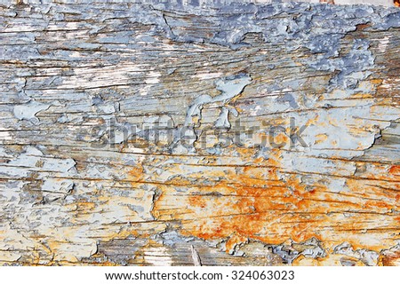 Image of a weathered wooden surface with the coat of paint peeling and falling off.