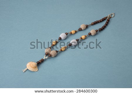 Necklaces handmade with sea shells, wooden beads, knitting with