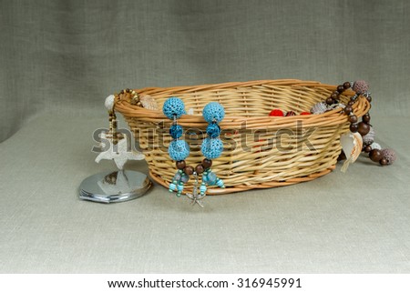 Crochet handmade beads with pendant starfish in a wicker basket on a gray background