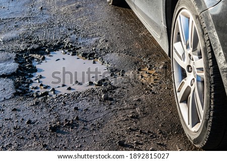 Similar – Foto Bild Pfützen auf einer Landstraße nach Regenfällen. Schwarz und weiß düstere Landschaft Szene