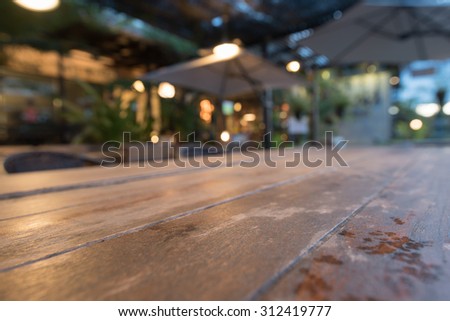 Table surface in coffee shop outdoor in the evening; blurred bokeh in the back.
