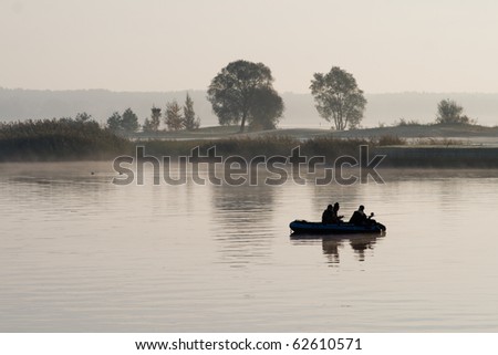 Boat with fishermen in the fog on the lake