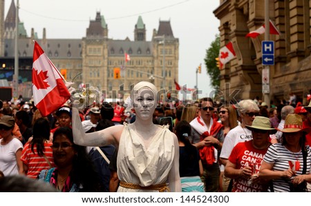 OTTAWA - JULY 1:  An unidentified statue busker stands still amongst the huge crowd near Parliament Hill in town for the annual Canada Day celebration July 1, 2013 in Ottawa, Canada.