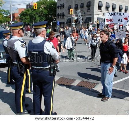 OTTAWA - AUG. 19: Protester hollers at 2 Royal Canadian Mounted Police during the protest of the Security and Prosperity Partnership talks in Ottawa, Canada on Aug. 19, 2007.