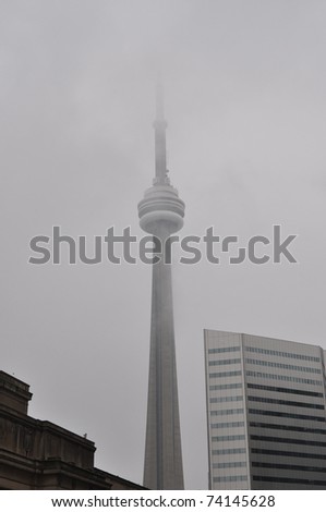 TORONTO, CANADA - MAR 12: A very thick fog on March 12, 2011 envelops downtown Toronto and makes part of the famous CN Tower, which stands 1,815 ft tall, not visible to the eye.  The tower is located in Toronto, Ontario, Canada.