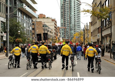 TORONTO, CANADA – OCT 15:  Police on bikes watch the crowd as they head to Saint James Park in downtown Toronto, for the Toronto version of Occupy Wall Street, Oct. 15 2011.