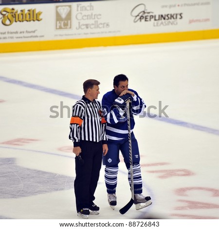 TORONTO, CANADA – NOV 13: Referee Kerry Fraser talks to Hall of Famer Doug Gilmour before interview during Hockey Hall of Fame Legends Classic game on Nov 13, 2011 in Toronto, Canada.