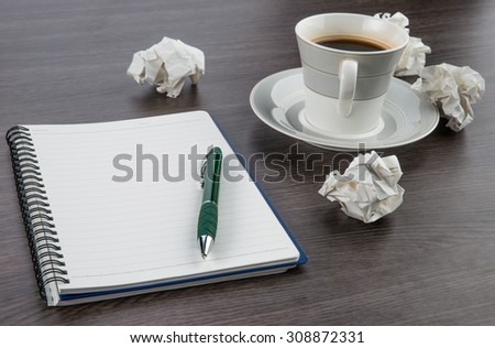 crumple paper, notebook and pen with cup of coffee on the desk