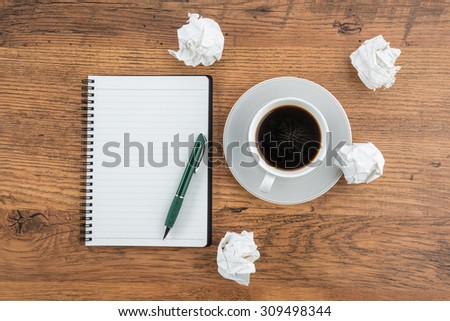 crumple paper, notebook and pen with cup of coffee on the desk