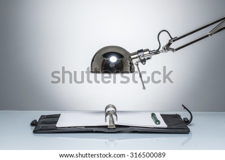 lighting up notebook diary writing with desk lamp on round studio lighting