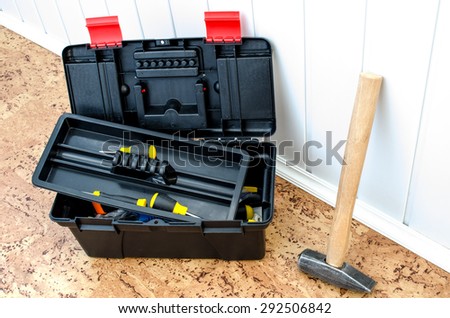 toolbox and a hammer near the wall