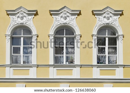 Palace windows decorated with portico and sculpture angel heads