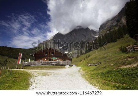 Old wooden Alpine Cabin with outdoor tables and benches in Austria
