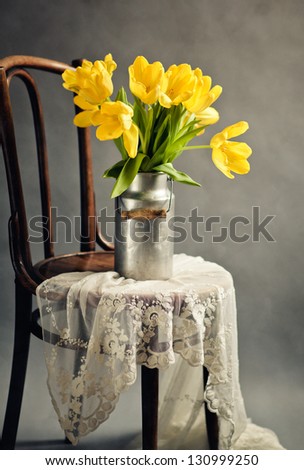 Beautiful bright yellow tulips in Still Life with old Milk Can on antique wooden Chair with Lace Cloth