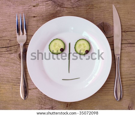 Vegetable Face on Plate with knife and fork, set on wooden board - Male, Sceptical