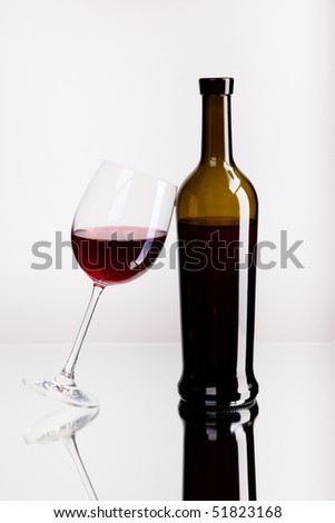 Glass and Bottle with Red Wine on mirror surface