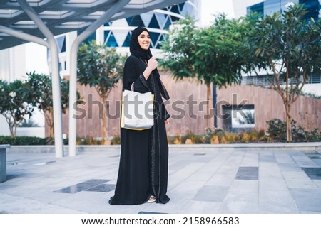 Image, Stock Photo Young Arab woman walking in the street using her smartphone