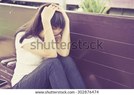 Portrait of a worried girl with hands over head