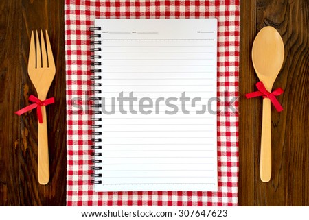 Blank recipe book on table with spoon