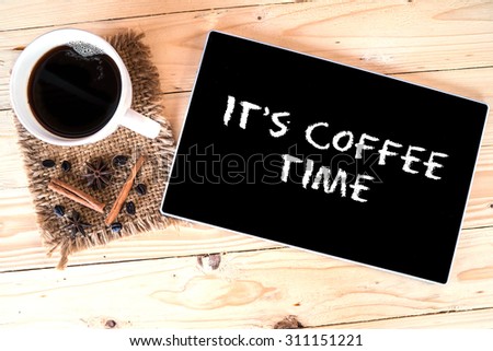 Cup of coffee, coffee beans, anise and cinnamon on wood table with it\'s coffee time text