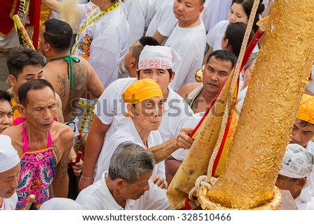 Unidentified man performing ceremony to the sacred wood poles is the symbol of the beginning of Phuket Vegetarian Festival October 12, 2015 in Phuket, Thailand