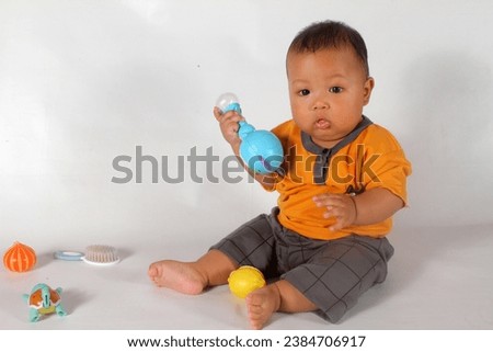 Similar – Image, Stock Photo 6 month old baby playing wearing black and white playing with colorful ring stack toy