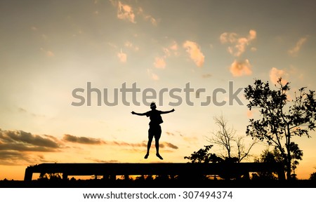 Man jump on the edge of the bridge sunset