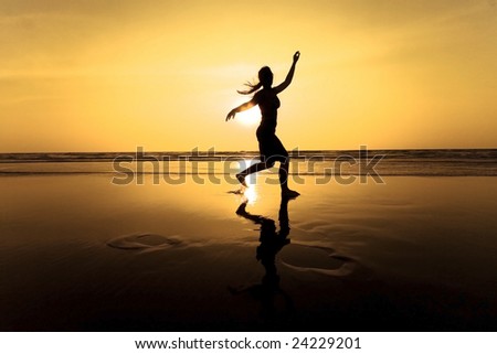 A silhouette of a women running at sunset on beach
